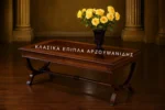 Κλασικό τραπέζι σαλονιού ORFEAS σε καφέ απόχρωση, με ορθογώνια επιφάνεια και διασταυρούμενα καμπύλα στηρίγματα