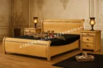 Κλασική Κρεβατοκάμαρα DANAI με ανοιχτόχρωμο κρεβάτι, καμπύλη γραμμή στο κεφαλάρι και στο ποδαρικό και κομοδίνα.