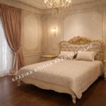 Κλασική Κρεβατοκάμαρα HERMES με ανοιχτόχρωμο διακοσμημένο πλαίσιο, επενδυμένο κεφαλάρι με χρυσαφί λεπτομέρειες και κομοδίνο.