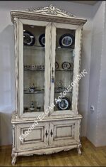Ψηλή ανοιχτόχρωμη κλασική βιτρίνα με γυάλινες πορτάδες, διακοσμημένη κορυφή και χαμηλή κλειστή βάση