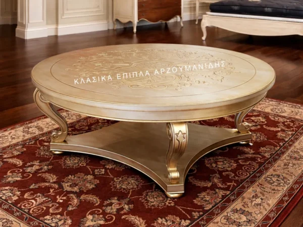 Κλασικό τραπέζι Σαλονιού ROTONTA σε ανοιχτή απόχρωση, με στρογγυλή επιφάνεια και καμπύλη σταυρωτή βάση με χρυσόχρωμο διάκοσμο