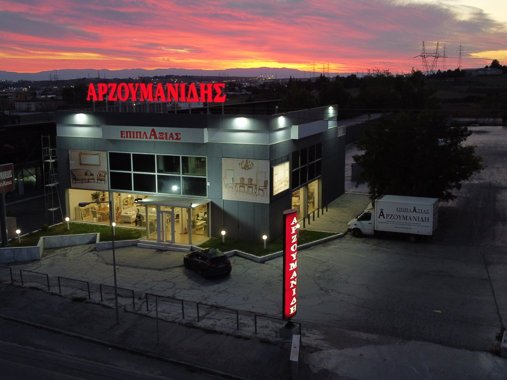Η έκθεση Κλασικών Επίπλων Αρζουμανίδης στη λεωφόρο Λαγκαδά στη Θεσσαλονίκη, με φωτισμένη πρόσοψη στο ηλιοβασίλεμα.