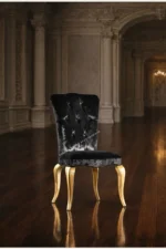 Κλασική καρέκλα ROYAL – μαύρη ταπετσαρία, ψηλή πλάτη με καπιτονέ και χρυσαφί καμπύλα πόδια σε διακοσμημένο χώρο