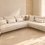Μοντέρνο σαλόνι Linea σε απόχρωση Ιβουάρ, με γωνιακή σύνθεση και λεπτά μαύρα πόδια σε φωτεινό χώρο με τραβερτίνη